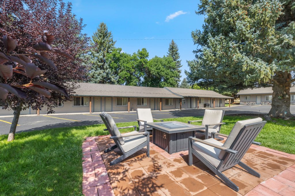Outdoor fire pit and lounge chairs on the lawn at the White River Inn in Meeker, Colorado